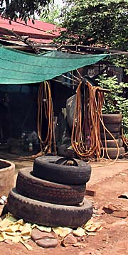 'Old Tyres and a Hose in a Workshop in Cambodia' by Asienreisender